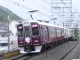雨の中高速で通過する阪急電車