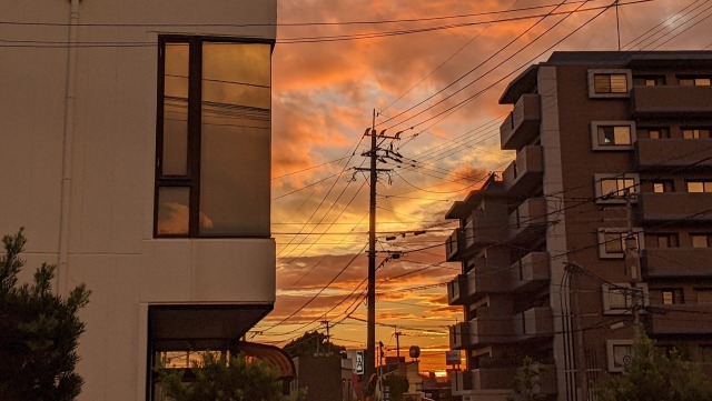 ビルと夕陽と赤い雲