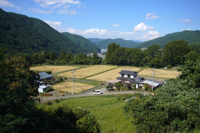 稲刈り終わる山村