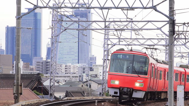 名駅ビル街と赤い電車